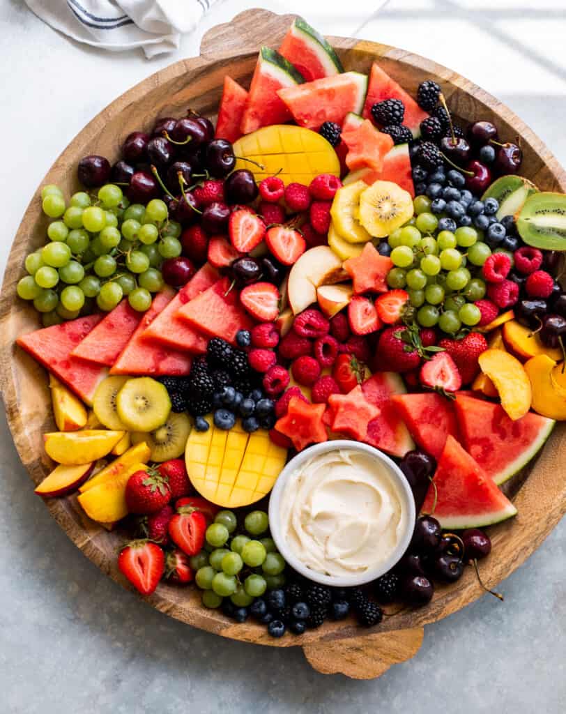 cut up fruit on a wooden platter.