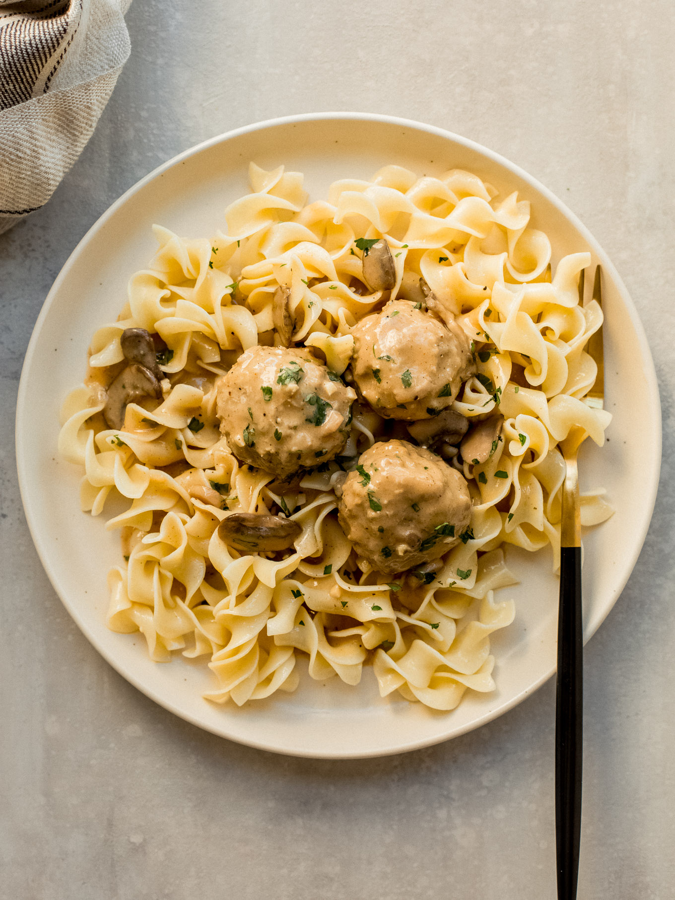 chicken meatballs with mushroom sauce served over cooked egg noodles.