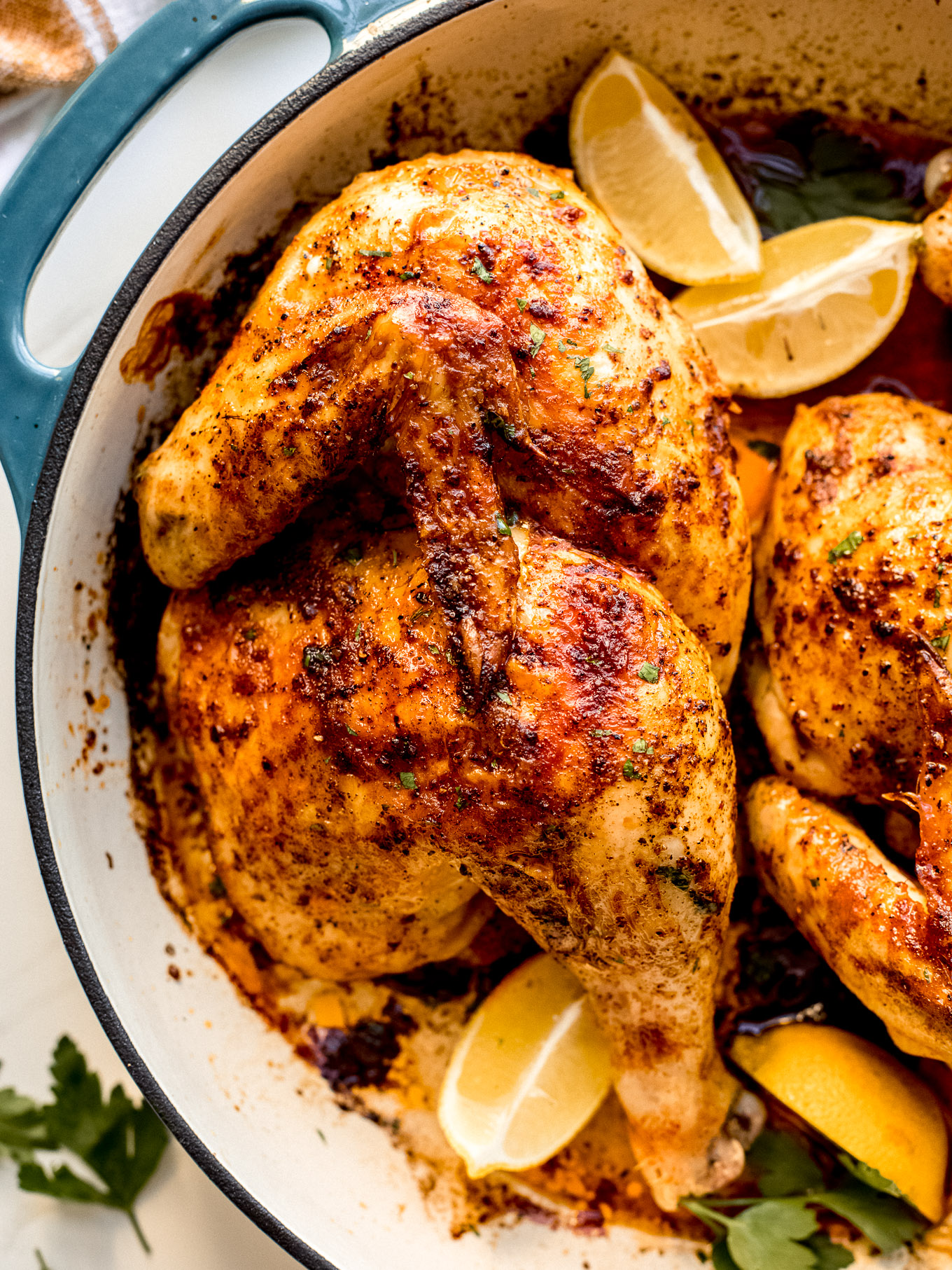 half chicken roasted with lemon in a pan. 