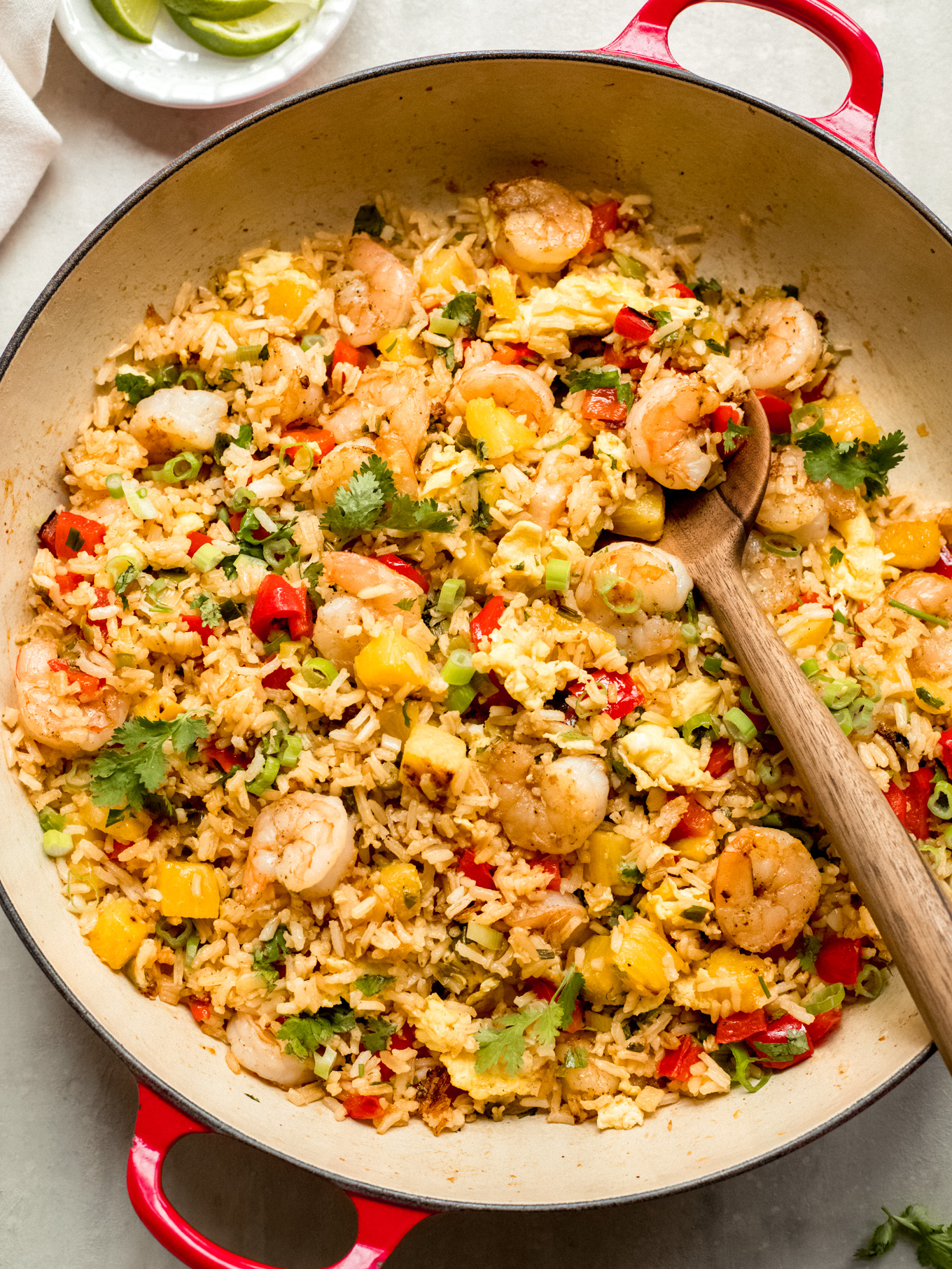 close up overhead photo of fried rice with shrimp with wooden spoon on the side.