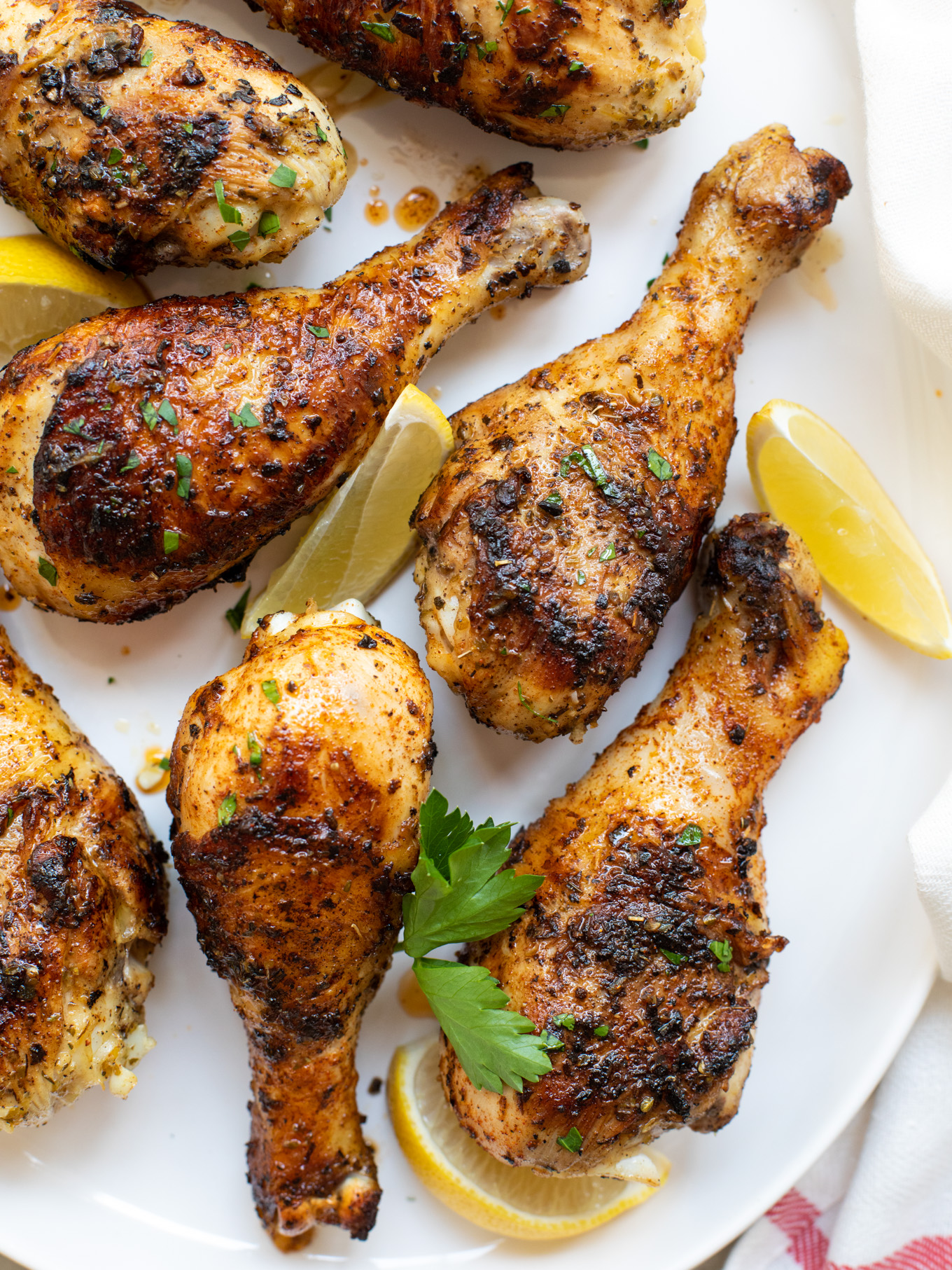 close up grilled chicken legs on a platter.