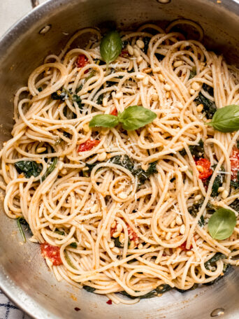 spaghetti with tomatoes and spinach in a saute pan.