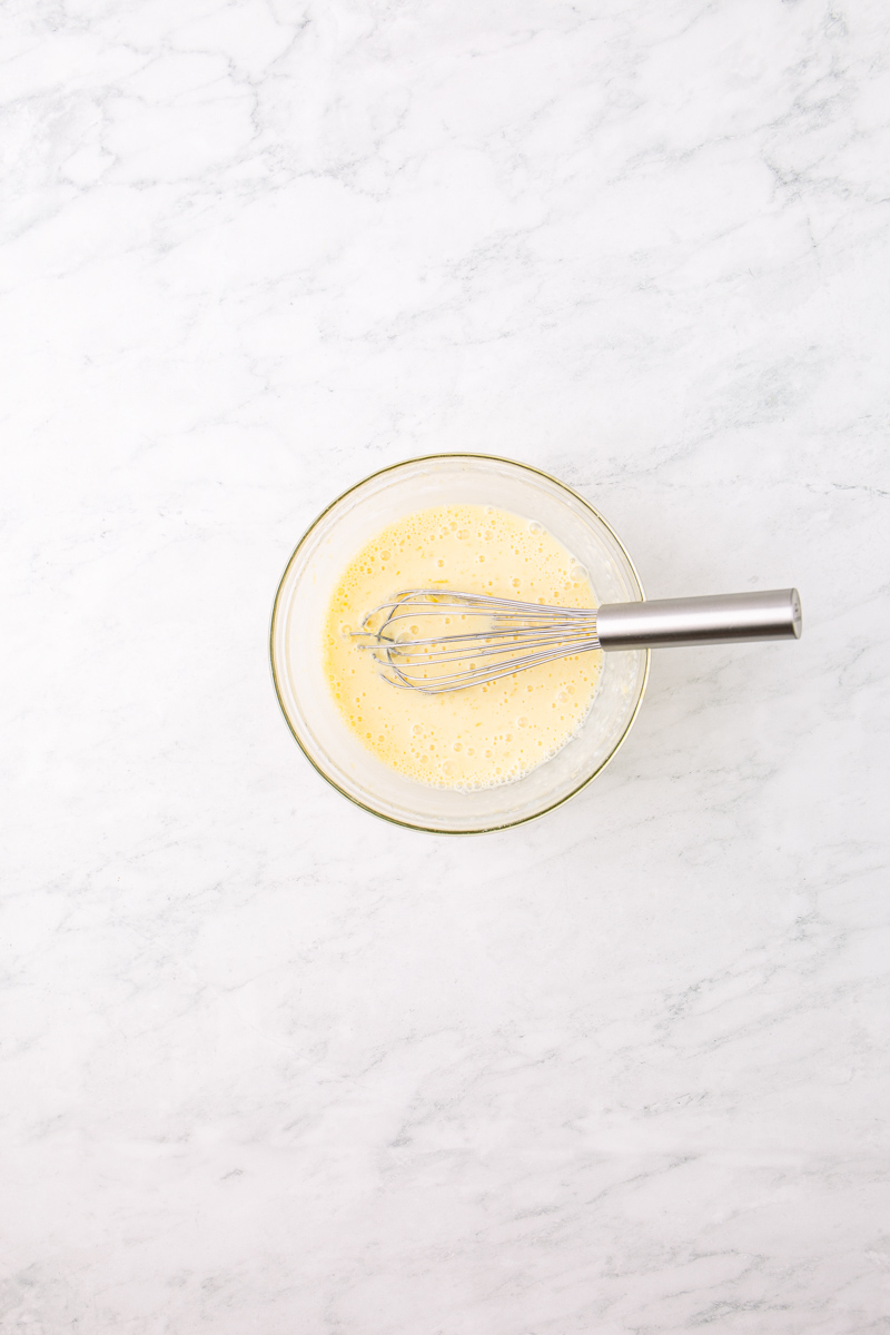 wet ingredients for pancakes in a glass bowl.