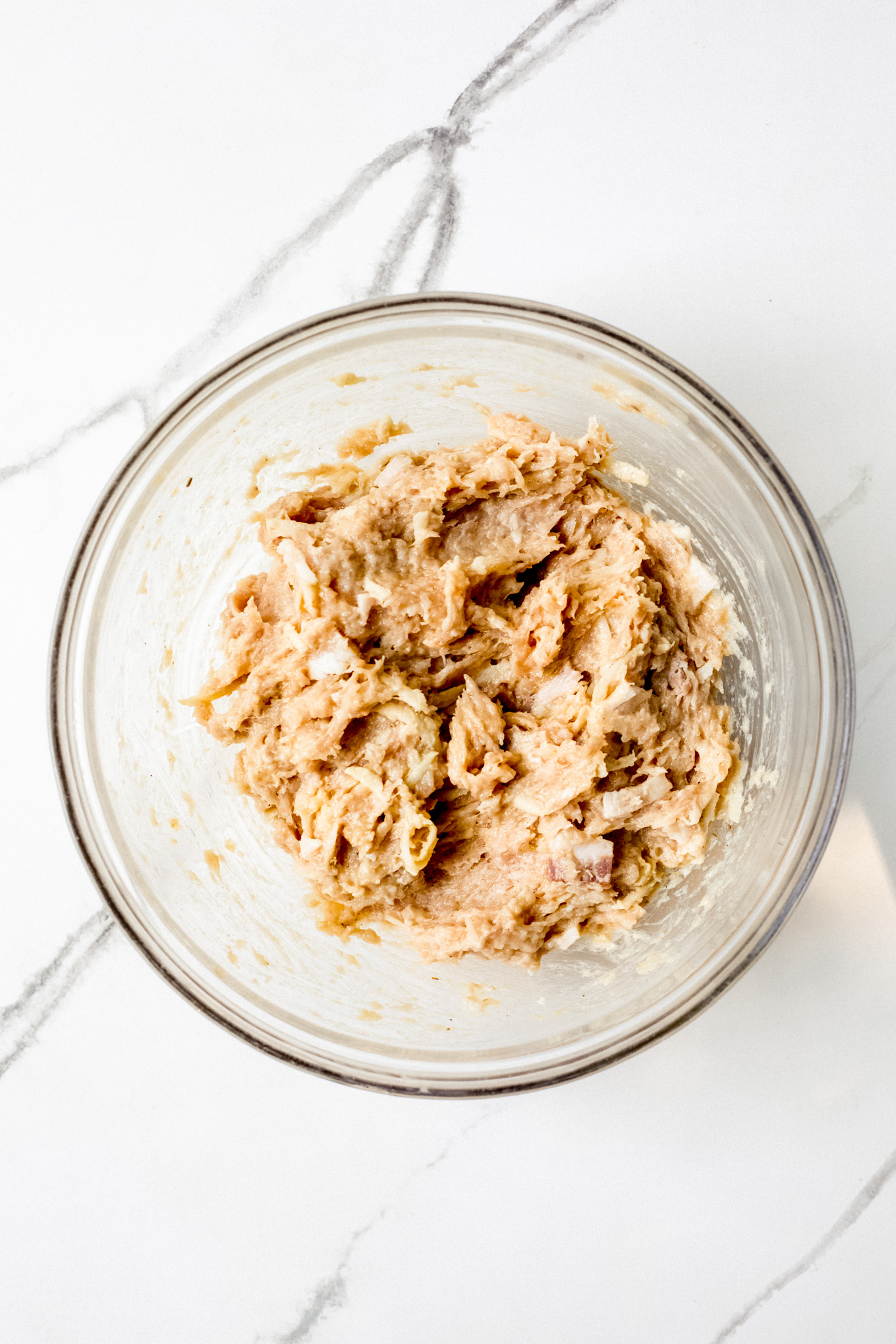 raw chicken patty meat mixture in a glass bowl.