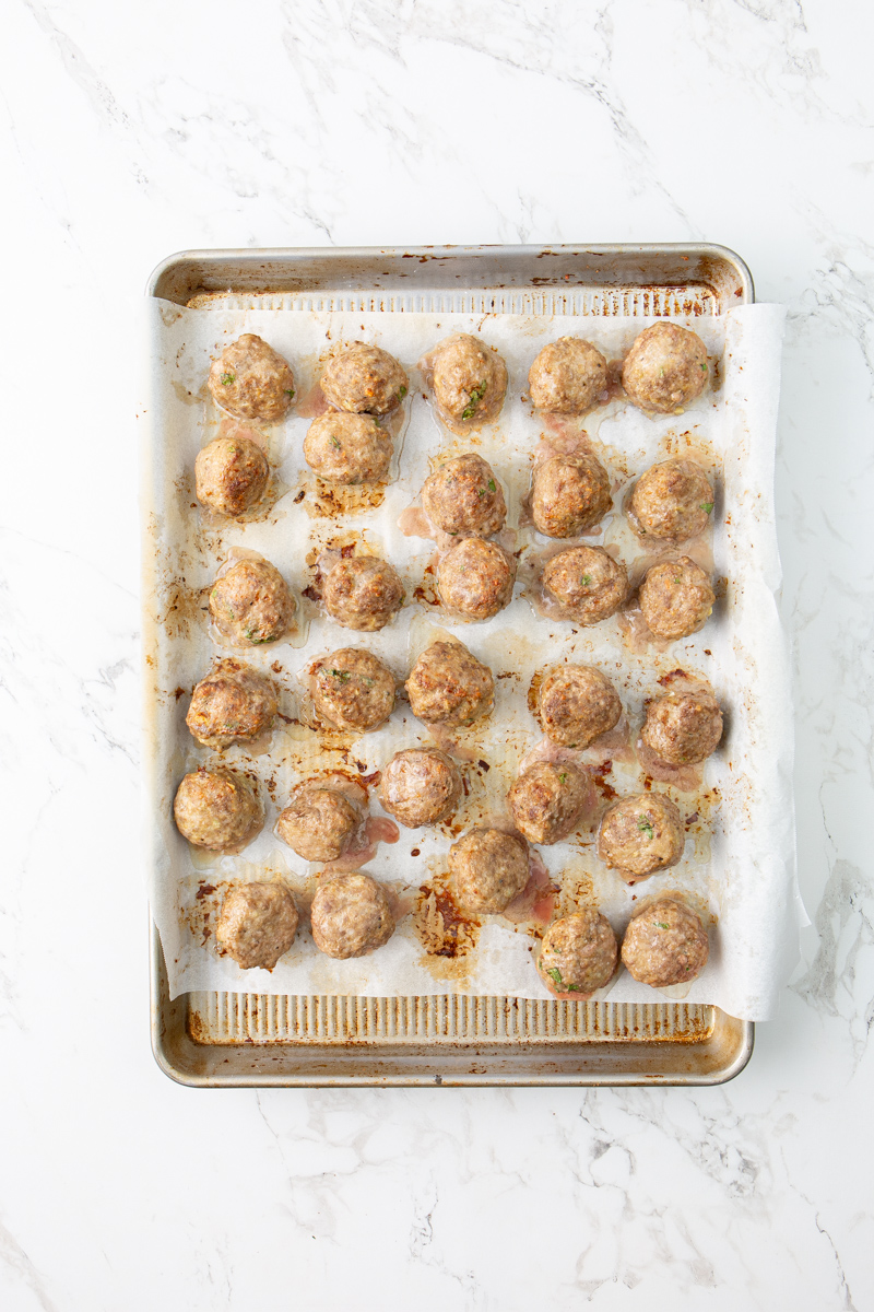 broiled meatballs on a baking sheet pan.