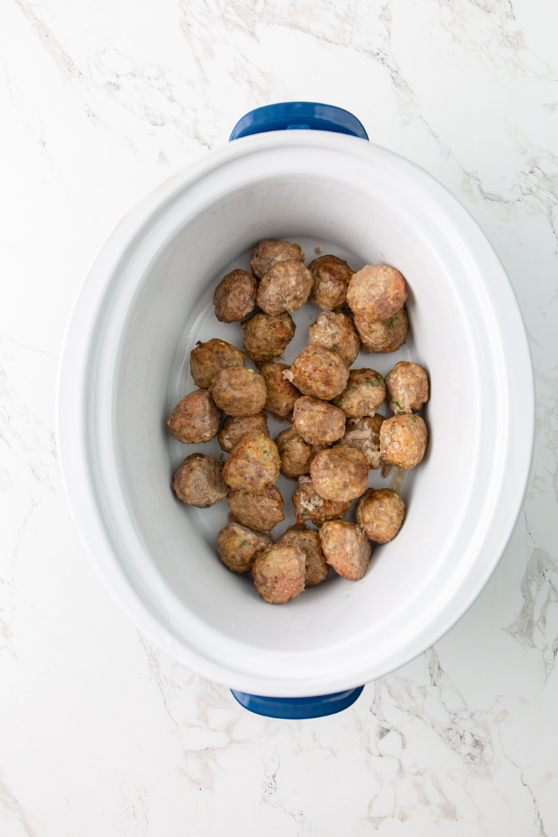 broiled meatballs inside a crockpot.