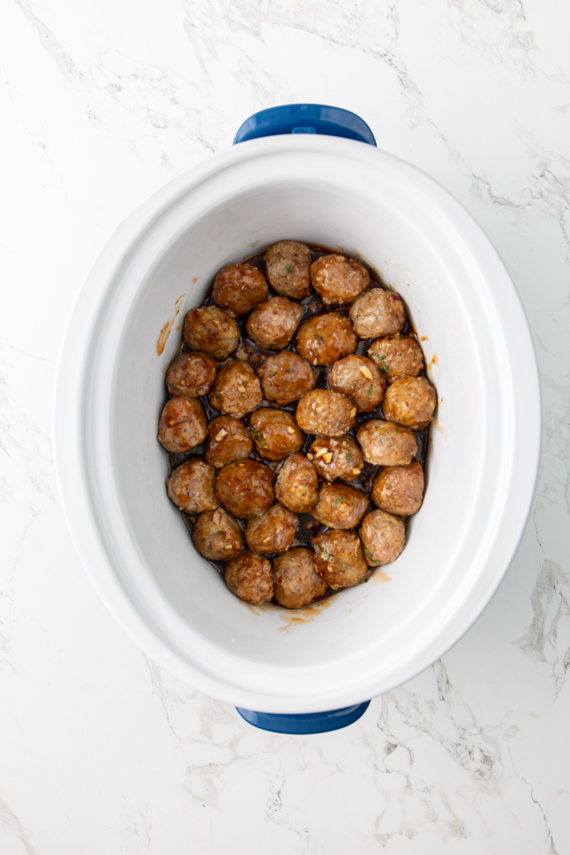 meatballs in a crockpot covered with sauce.