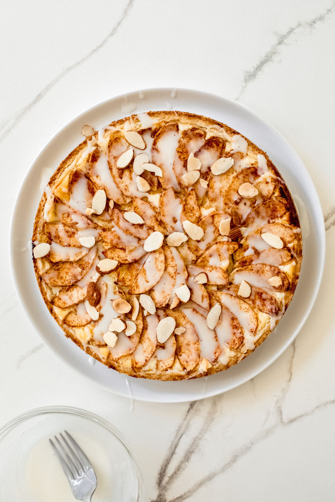apple tart topped with glaze and sliced almonds.