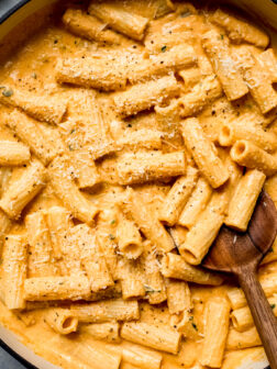 pumpkin pasta sauce tossed with cooked pasta in a saute pan.