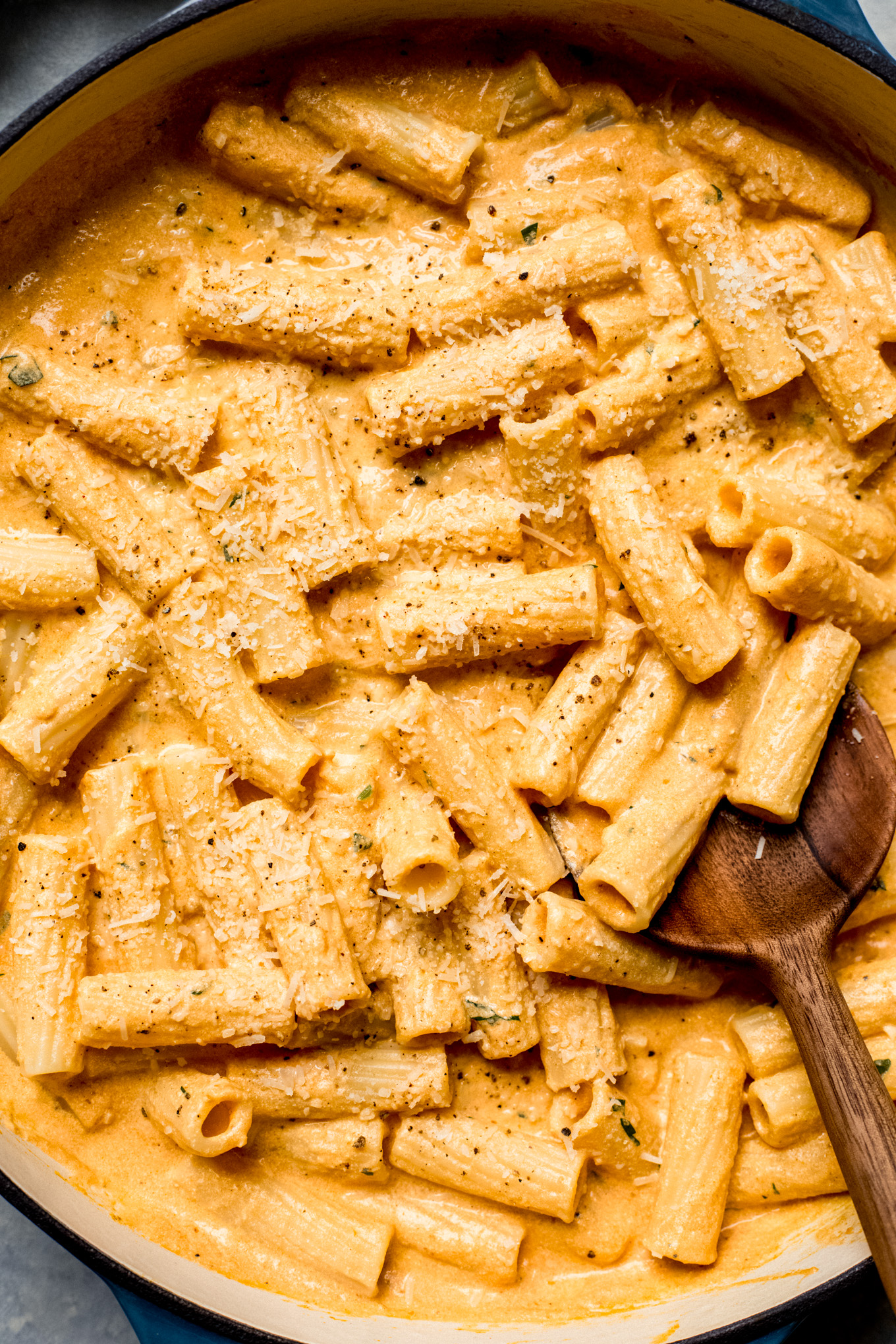 pumpkin pasta sauce tossed with cooked pasta in a saute pan.