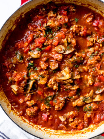 sausage cacciatore in a red saute pan.