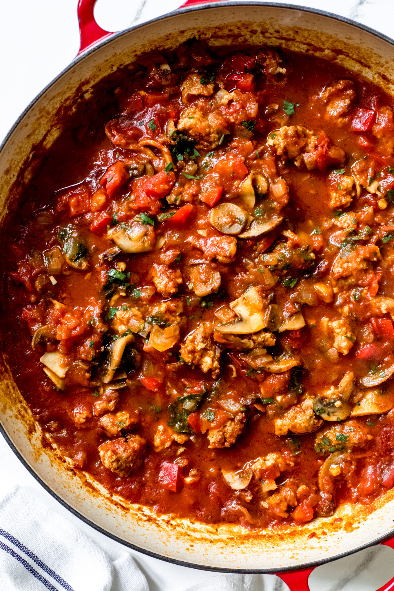 sausage cacciatore in a red saute pan.