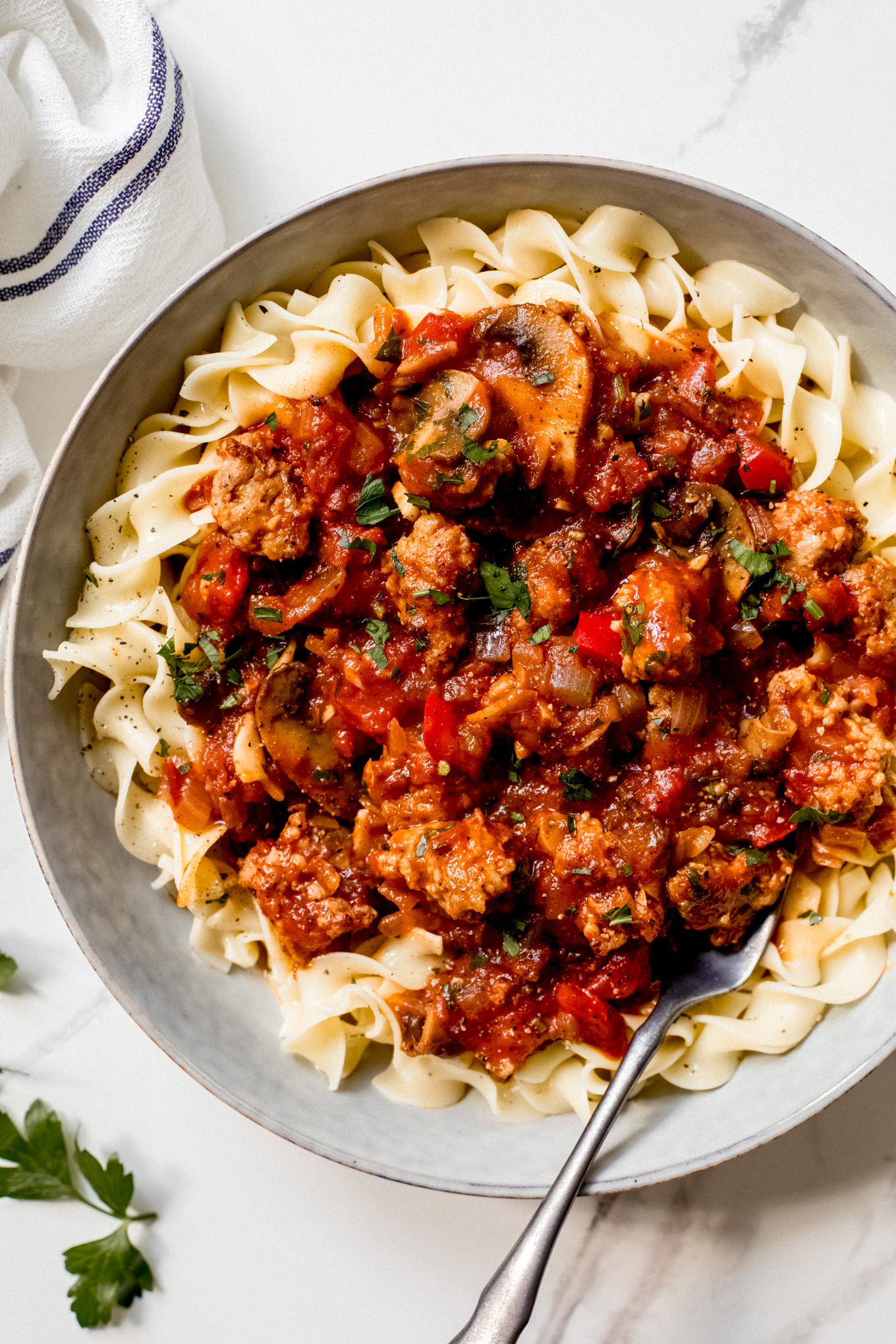 sausage cacciatore over cooked egg noodles.