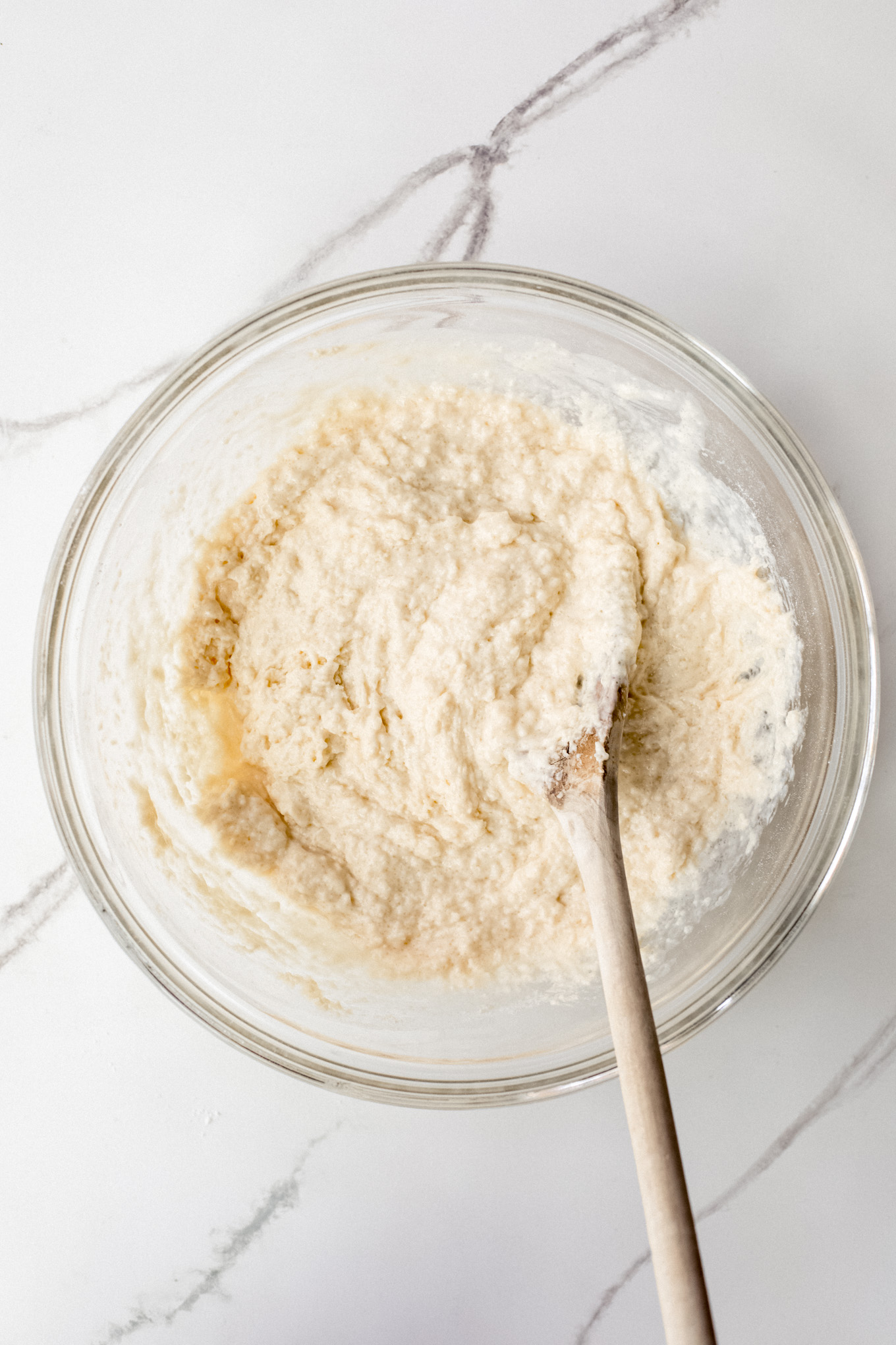 cake batter in a bowl with a wooden spoon.