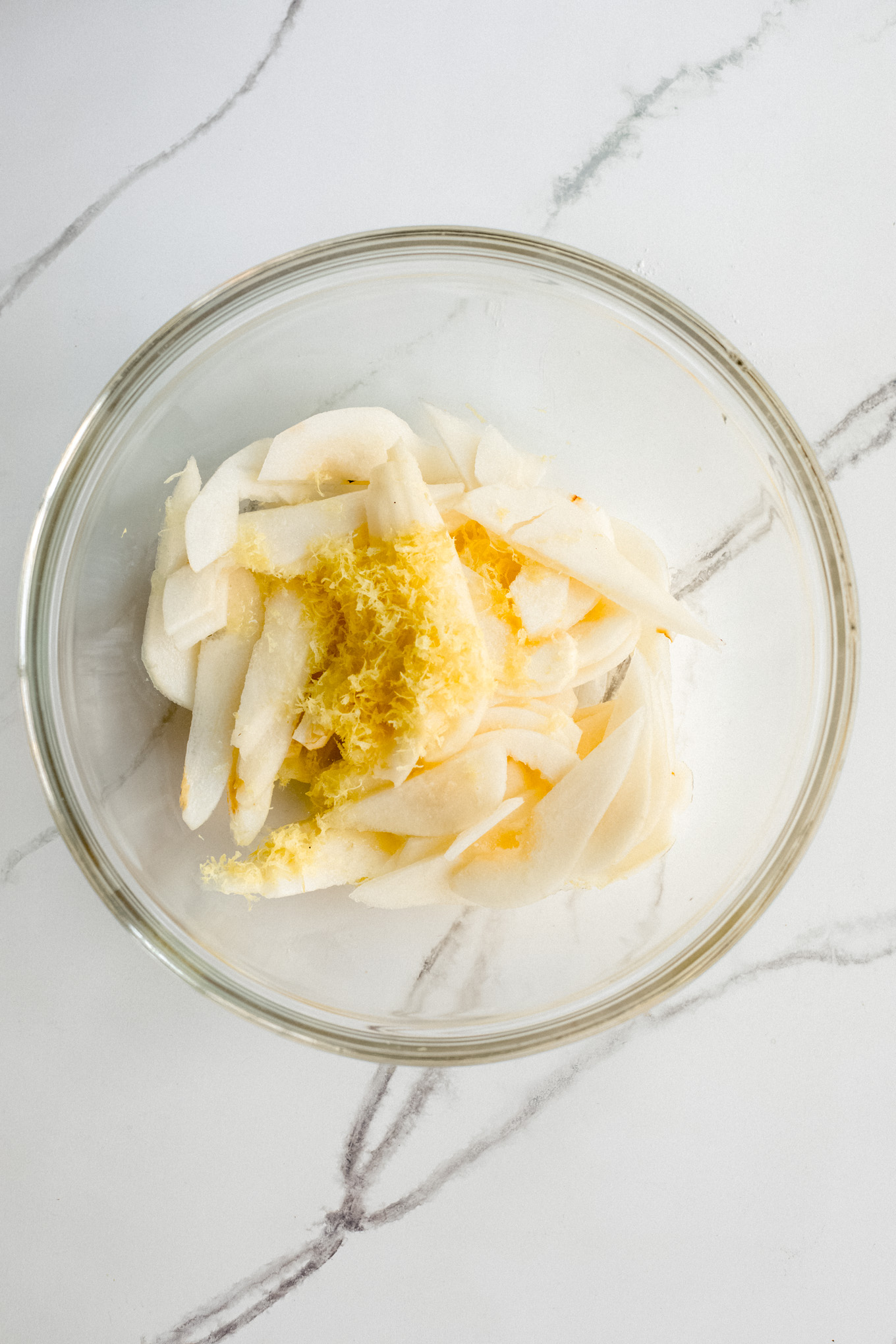 sliced pears with lemon zest in a bowl.