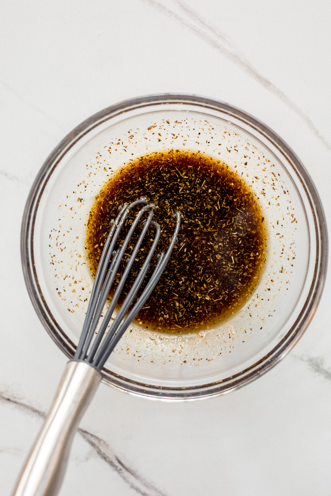 balsamic vinegar and oil in a bowl with a whisk.