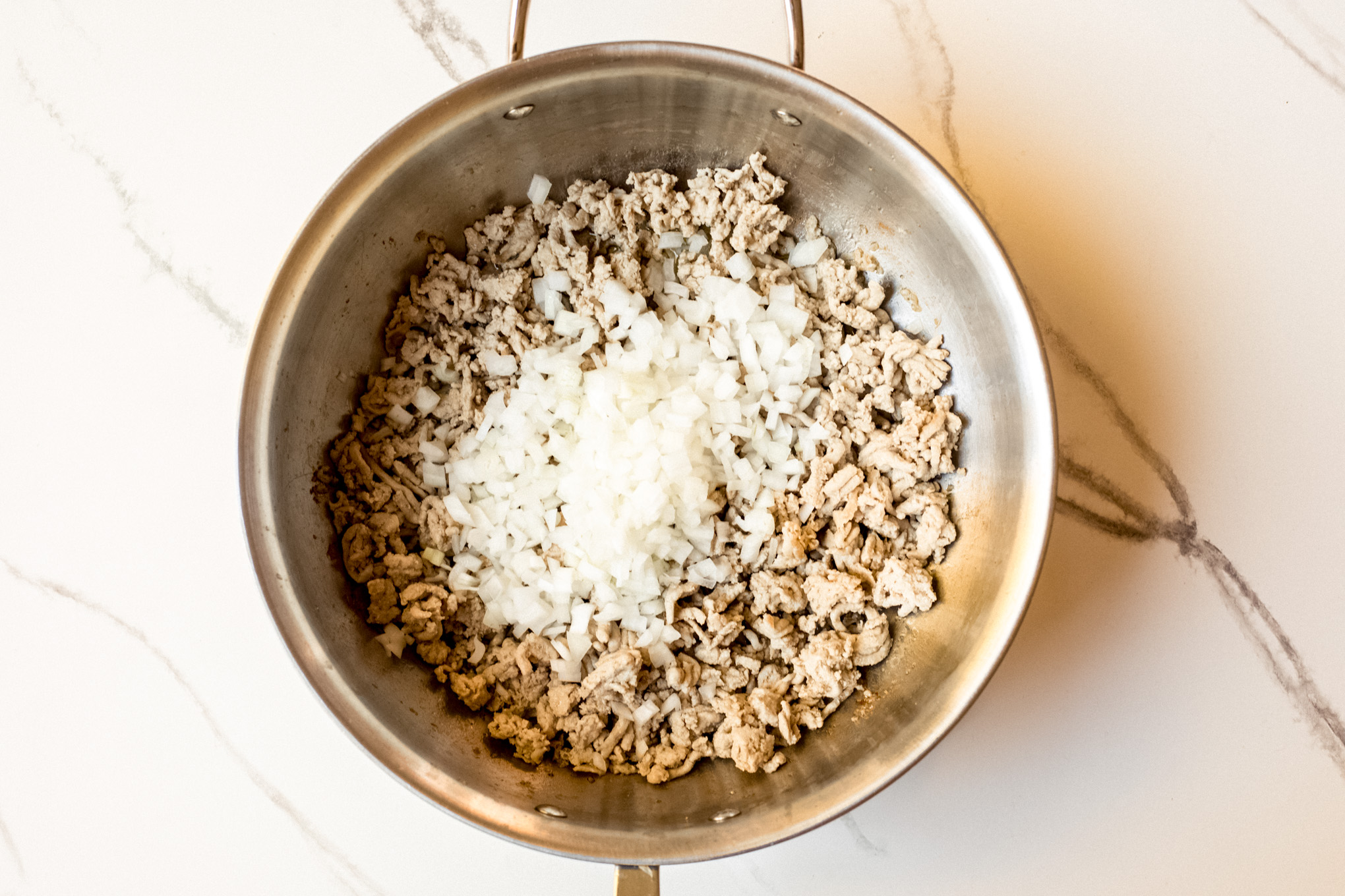 cooked ground turkey with onions in a pot.