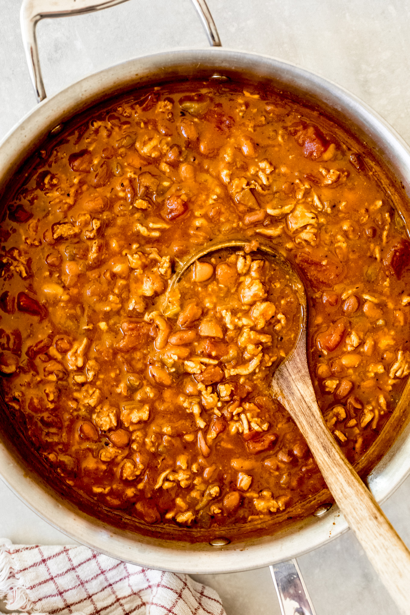 pumpkin chili in a dutch oven with wooden ladle on the side.