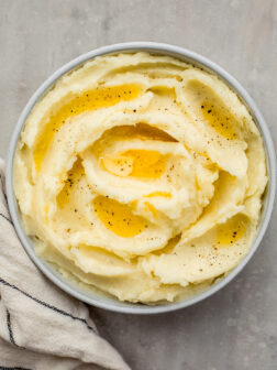 yukon gold mashed potatoes in a bowl with melted butter over the top.