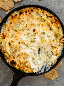 baked artichoke dip in a cast iron skillet.