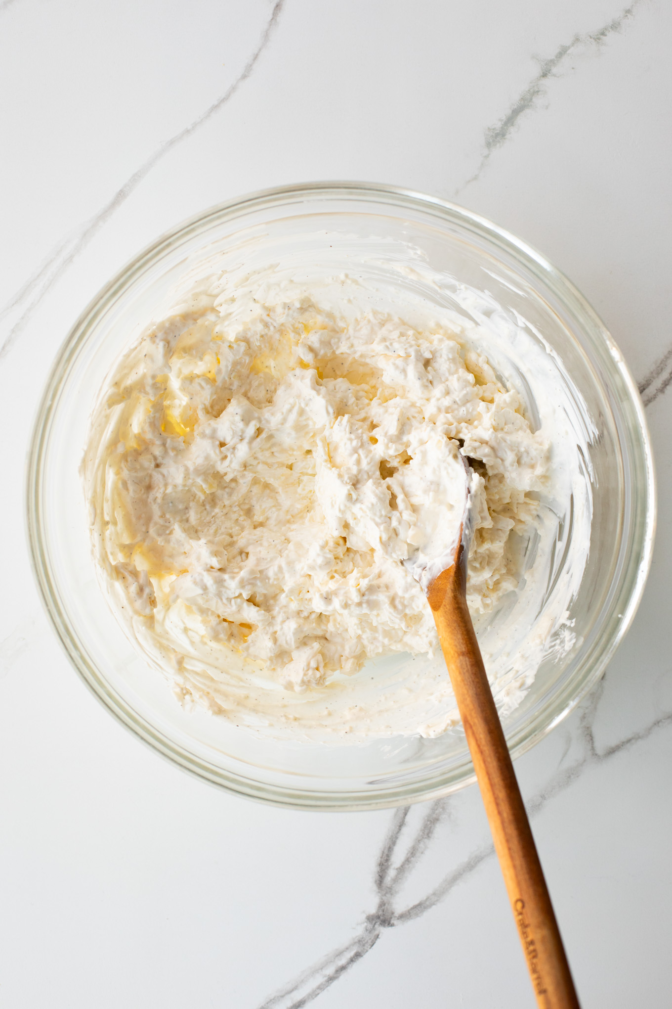 creamed cream cheese and cheese in a glass bowl.