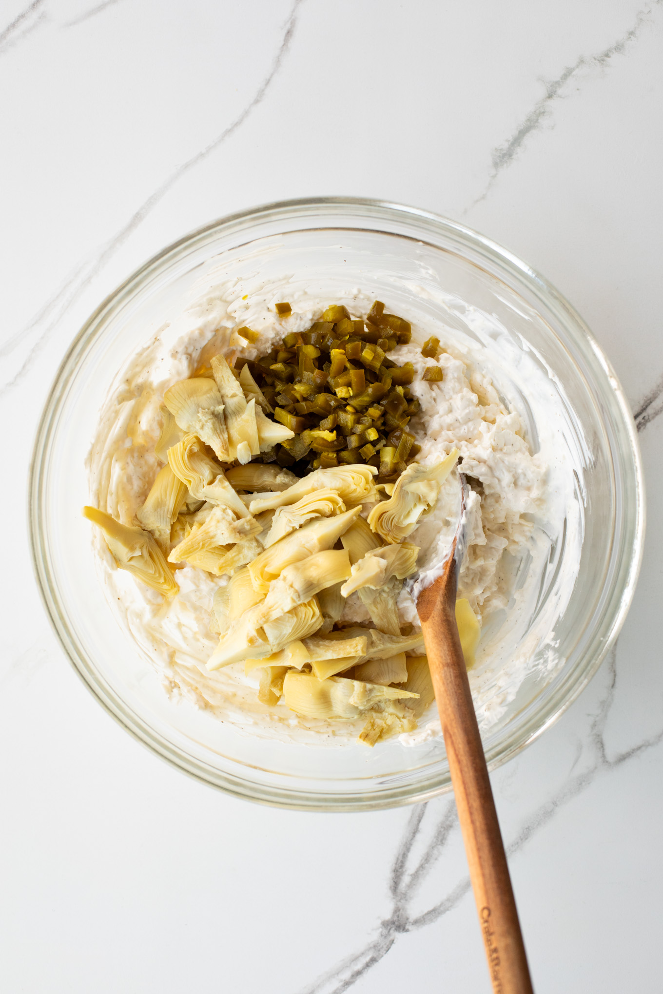 artichoke and jalapenos in a glass bowl.