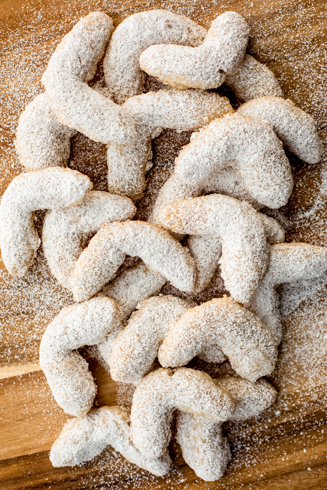 walnut crescent cookies on a cutting board.