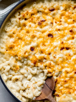 baked mac and cheese with wooden spoon on the side.