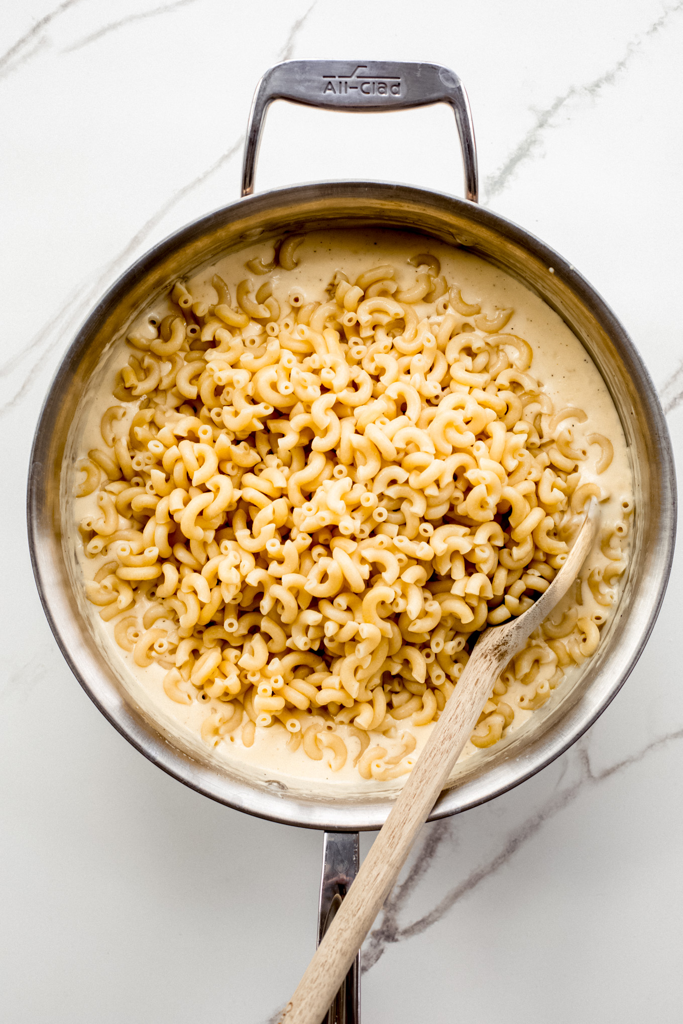cooked macaroni with cheese sauce in a pan.