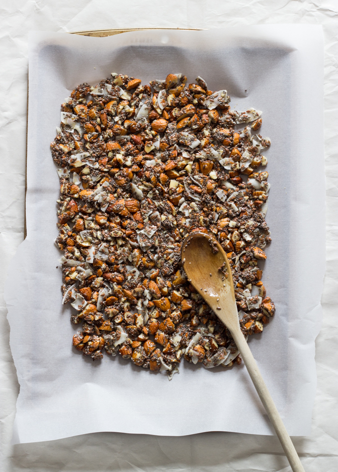 nut and seeds mixture spread on a parchment lined baking sheet.