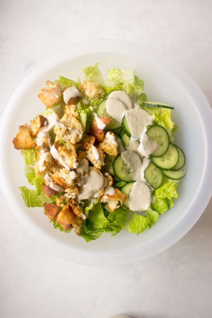 chopped romaine, cucumbers, and croutons covered in Caesar dressing.