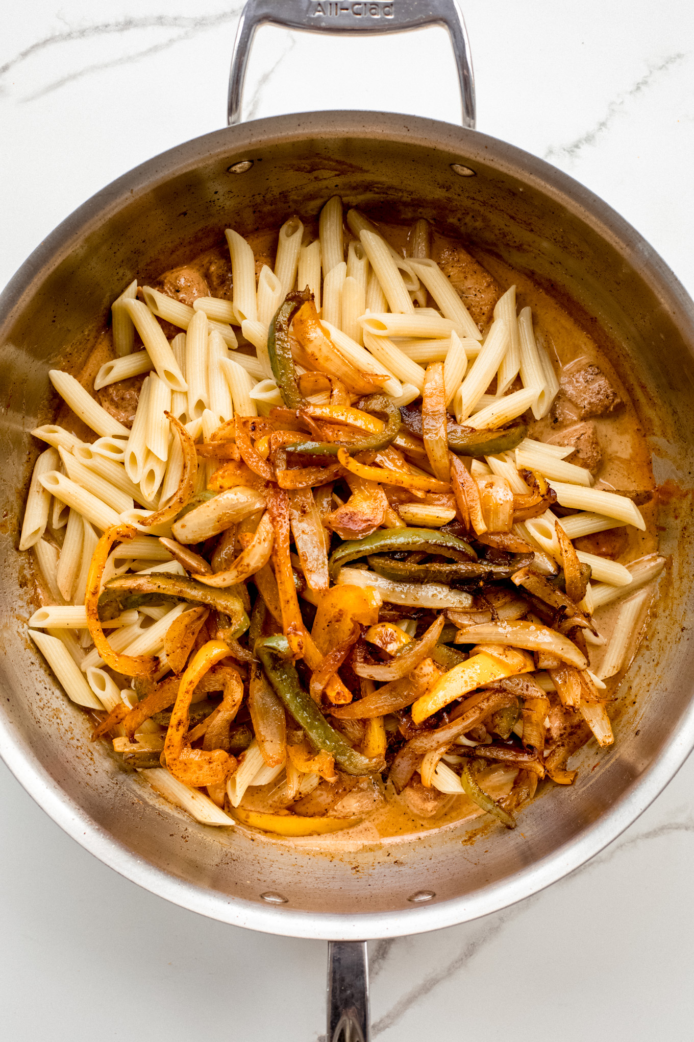 cooked pasta with peppers and chicken in sauce.