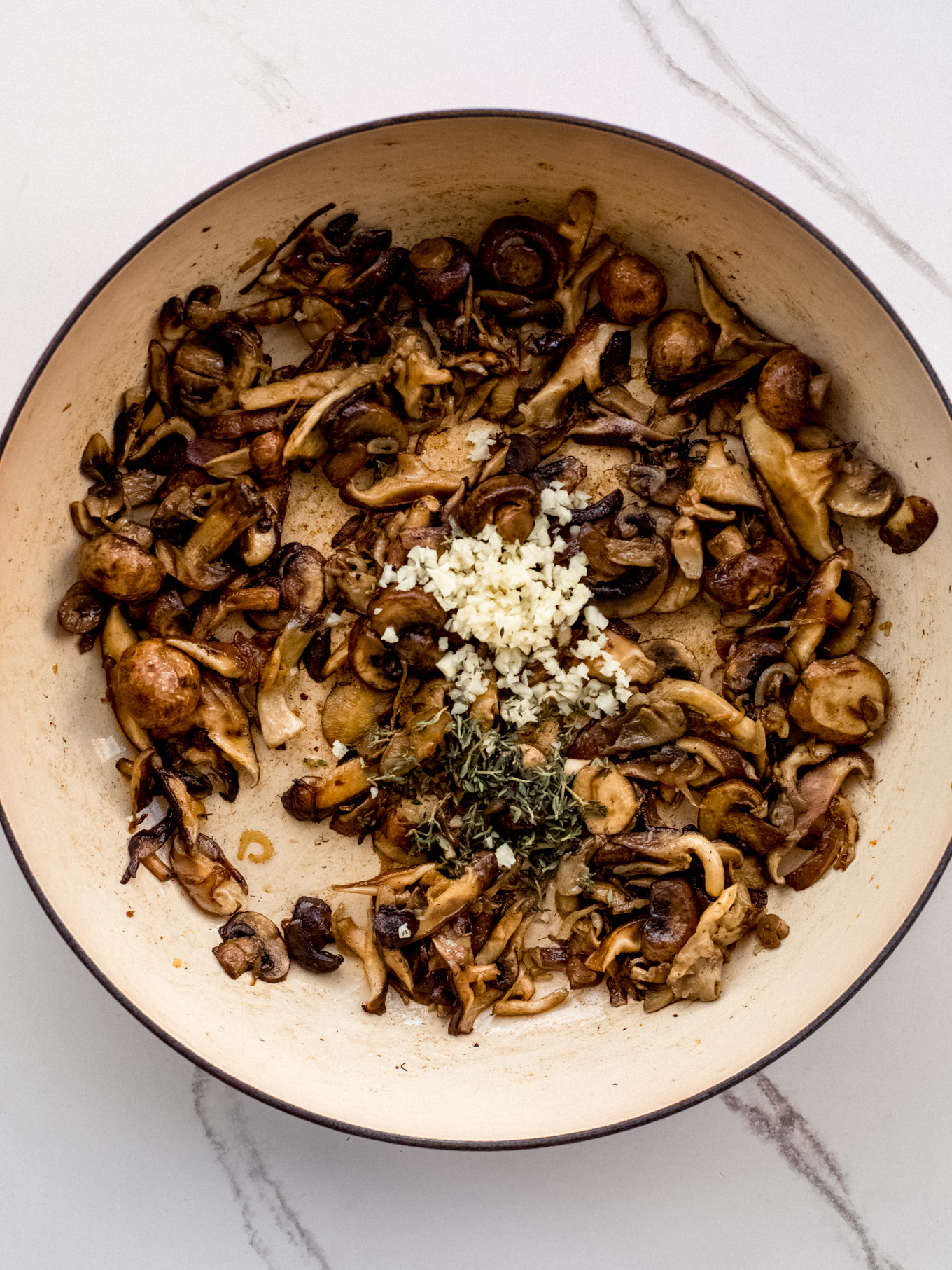 sauteed mushrooms in a saute pan with garlic.