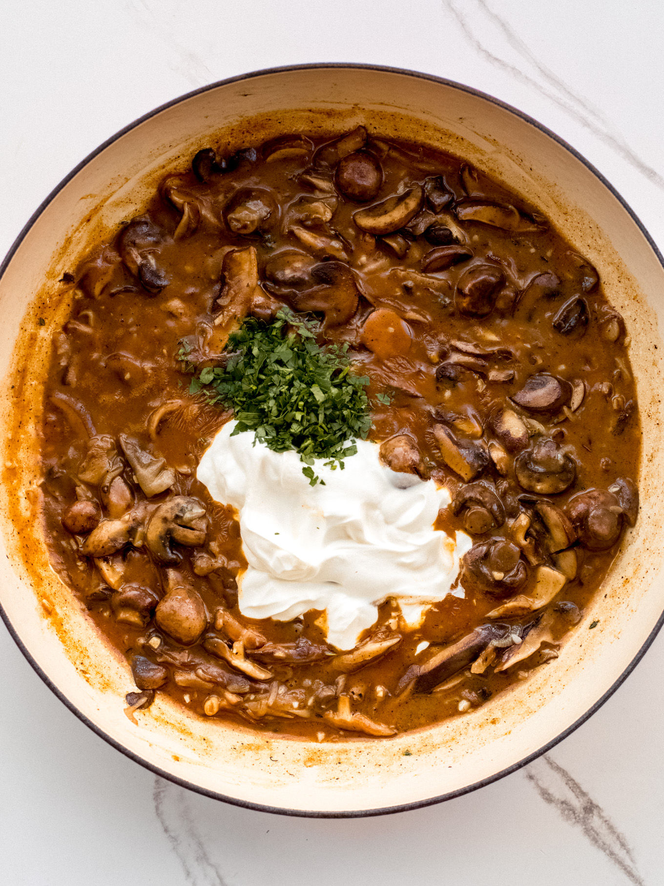 sour cream and parsley over cooked mushrooms.