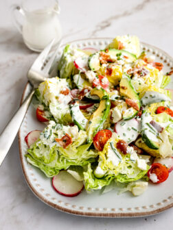 Chopped iceberg lettuce salad with tomatoes, radishes, and bacon.