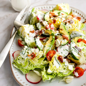 Chopped iceberg lettuce salad with tomatoes, radishes, and bacon.