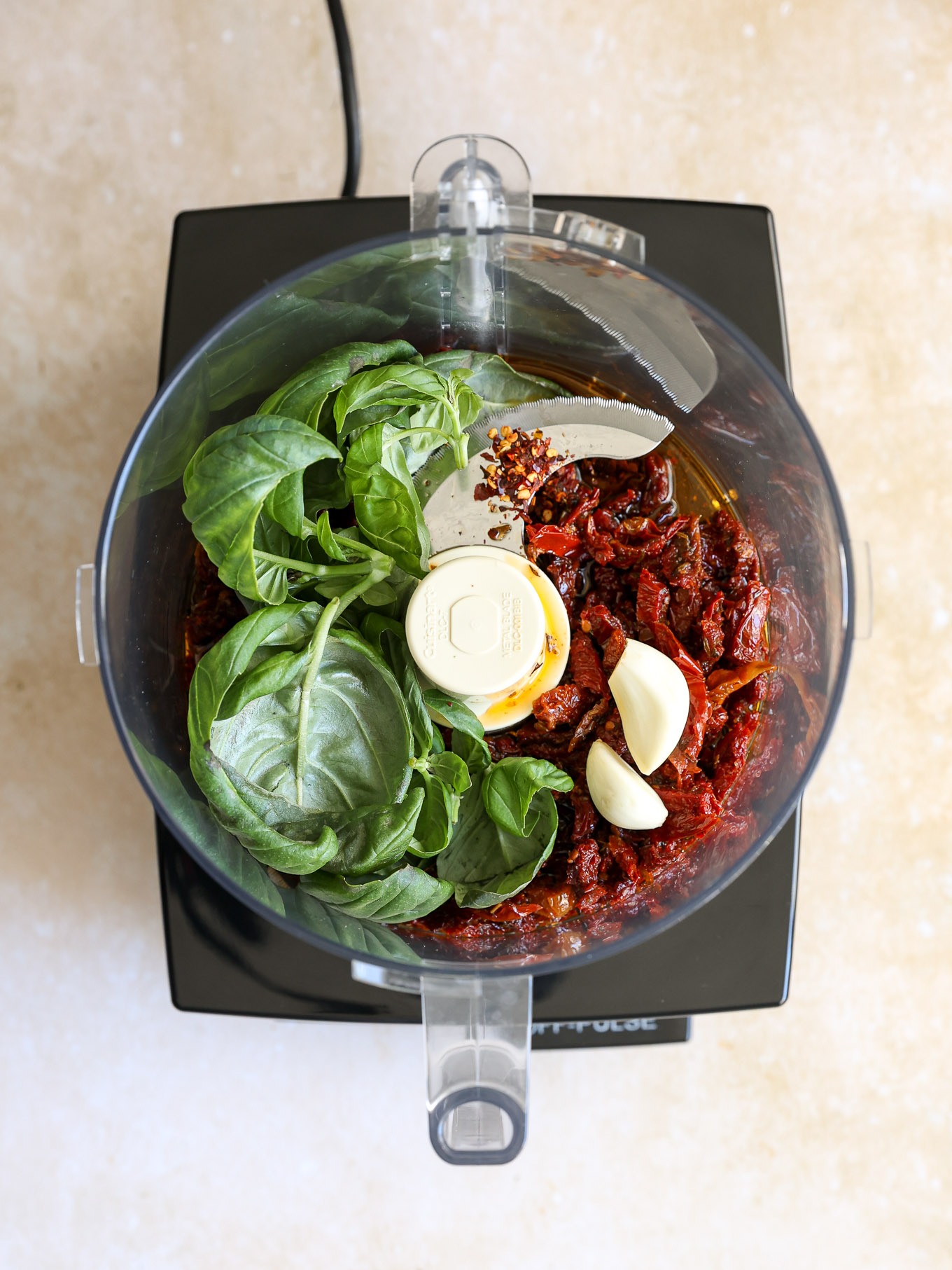 sun dried tomatoes with spinach and garlic in a food processor.