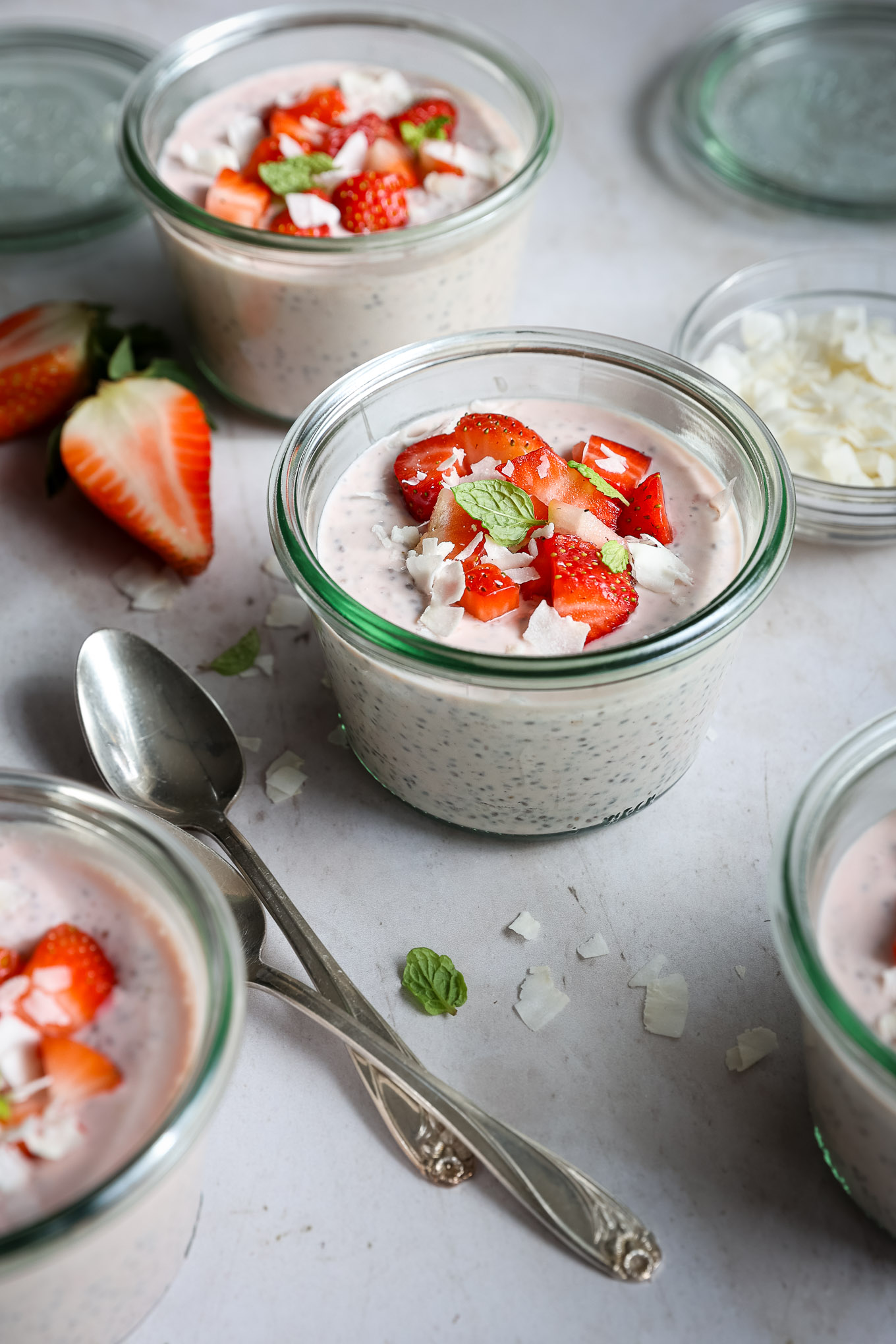chia seed pudding in a glass jar with a spoon topped with coconut.