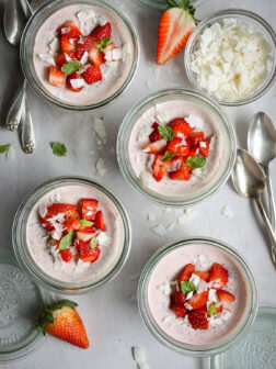stawberry chia seed pudding in glass jars topped with fresh strawberries.