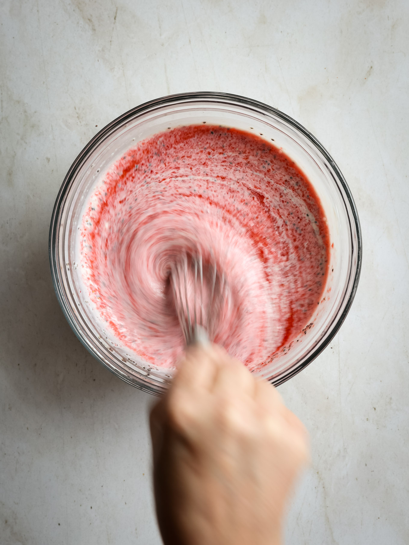 pureed strawberries with yogurt mixture in a glass bowl.