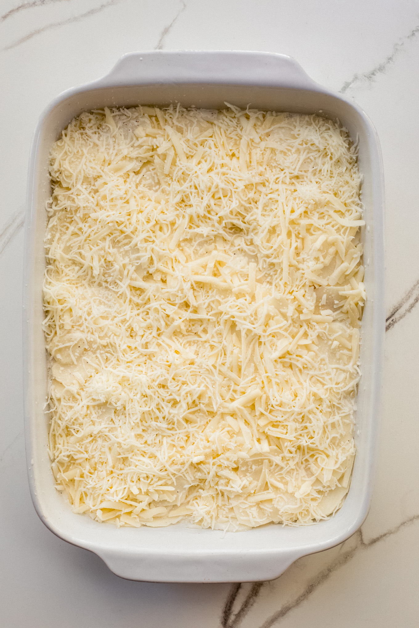 casserole with potatoes covered with shredded cheese.