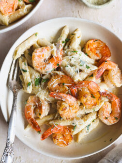 lemon shrimp pasta in a white bowl garnished wiht parsley.