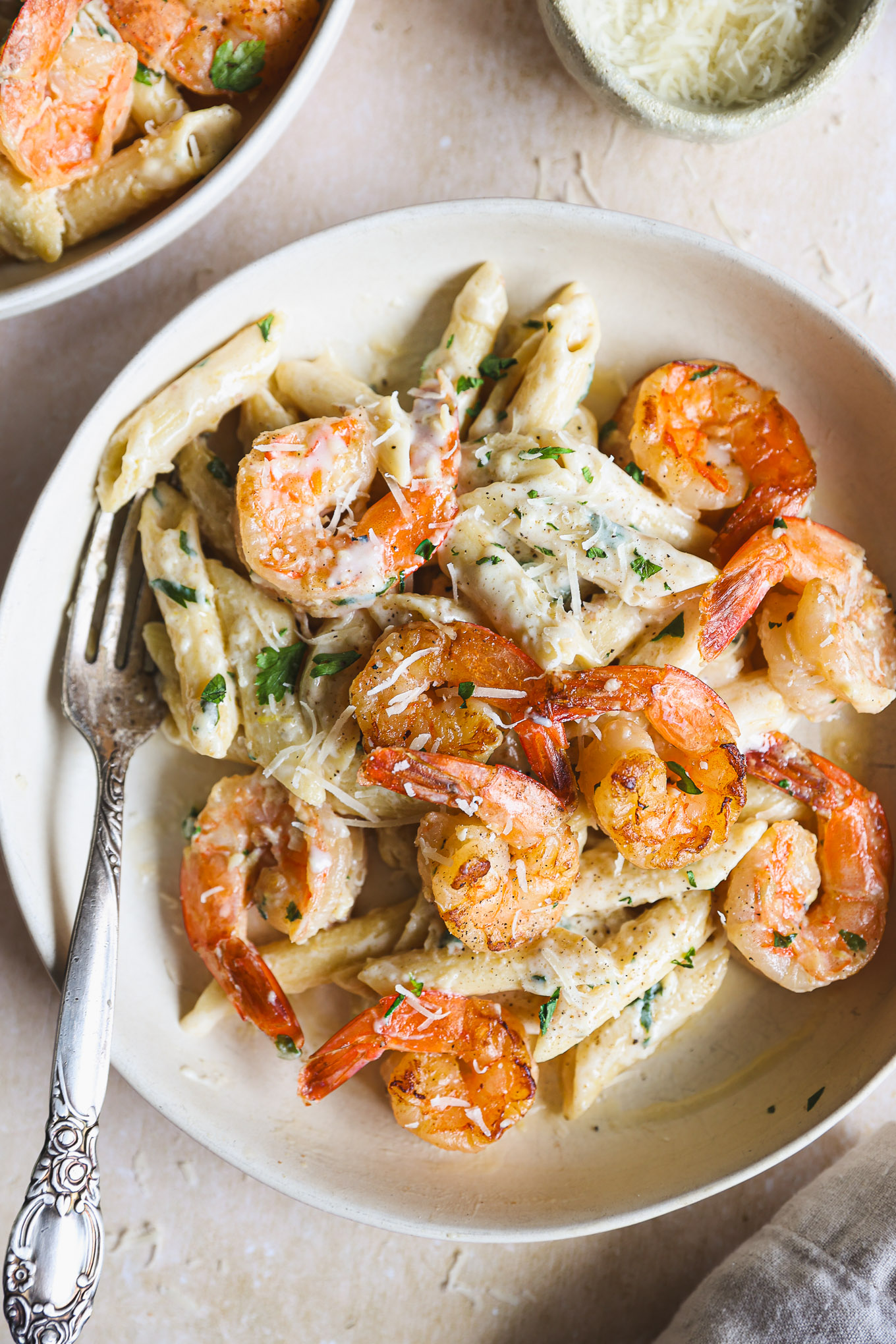 lemon shrimp pasta in a white bowl garnished wiht parsley.