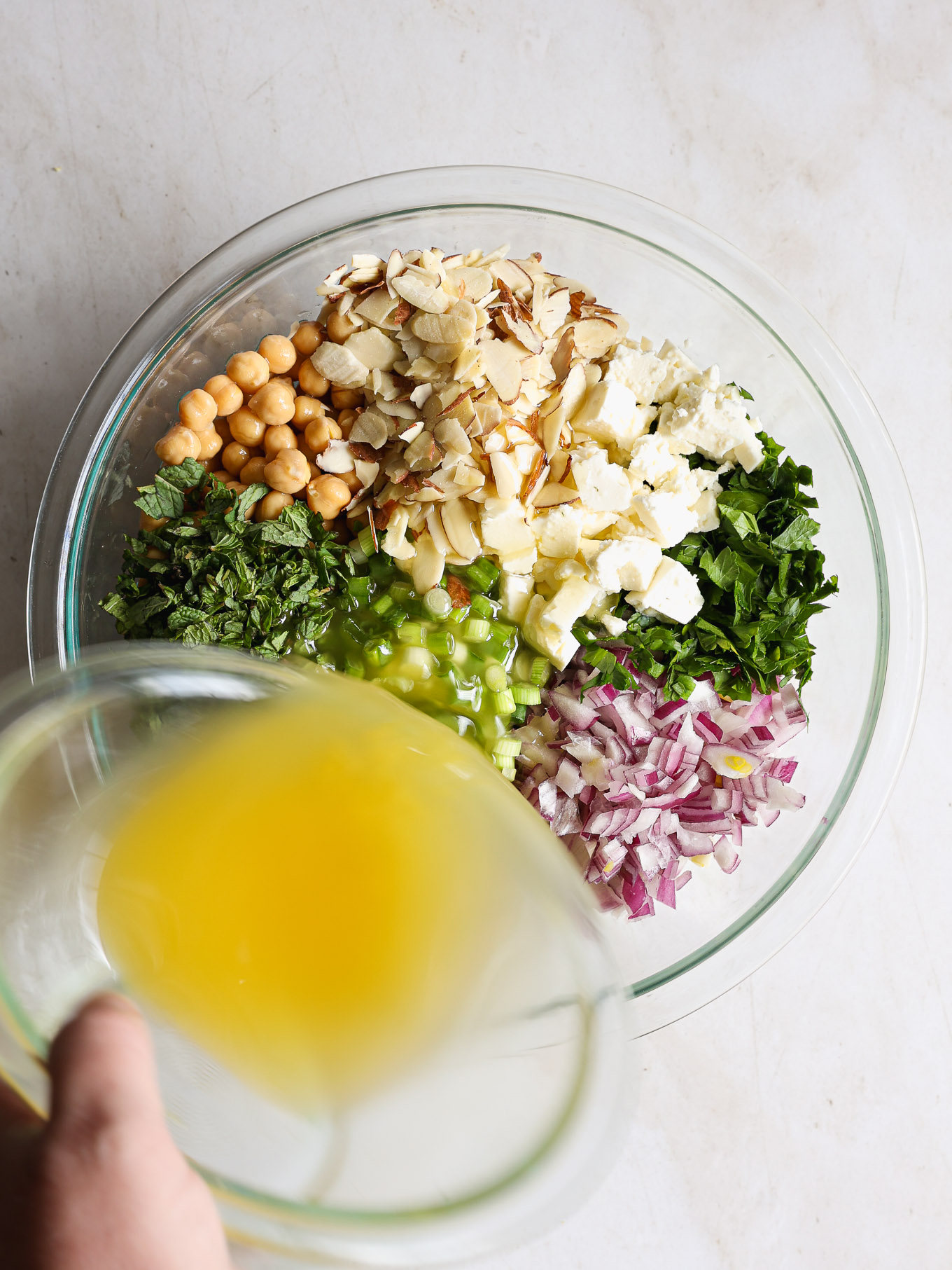 orzo feta salad in a bowl with dressing.