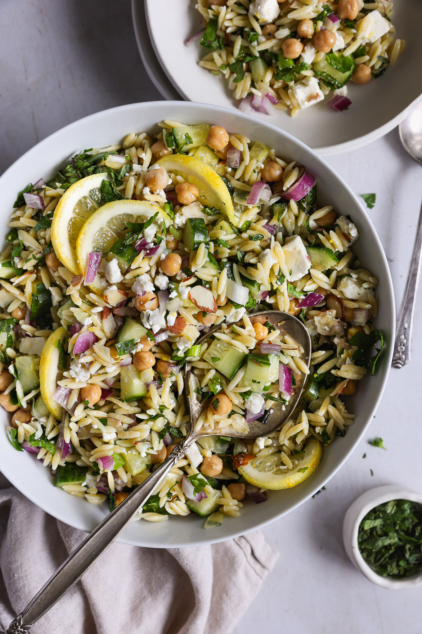 orzo salad recipe with feta in a bowl with a side of spoon.