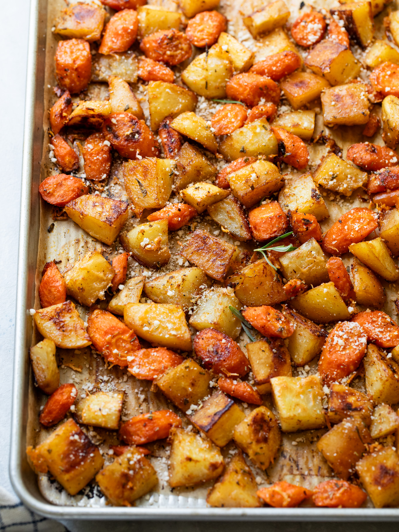 close up carrots with potatoes on a sheet pan.