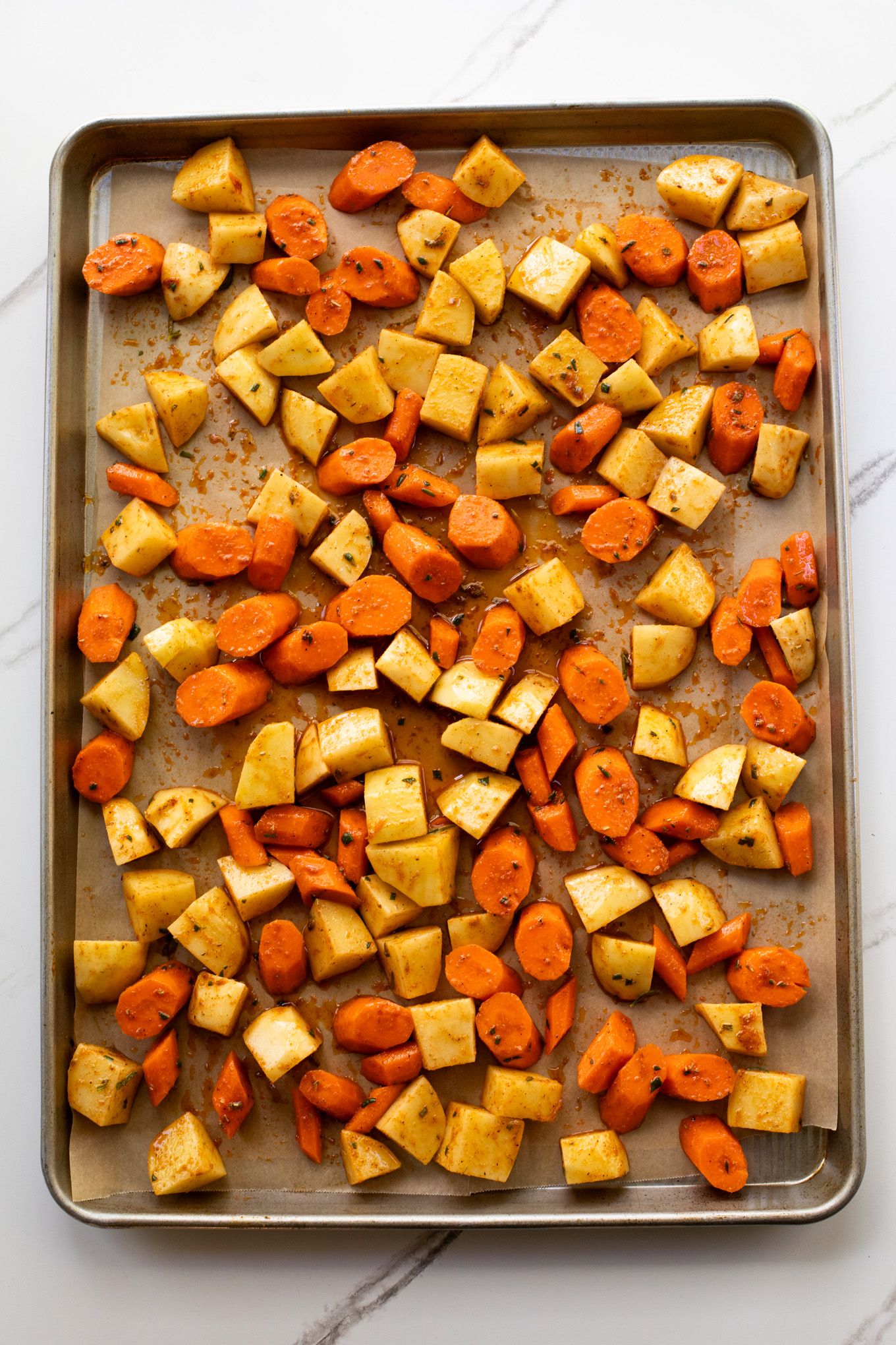 cut up potatoes and carrots on a baking sheet.