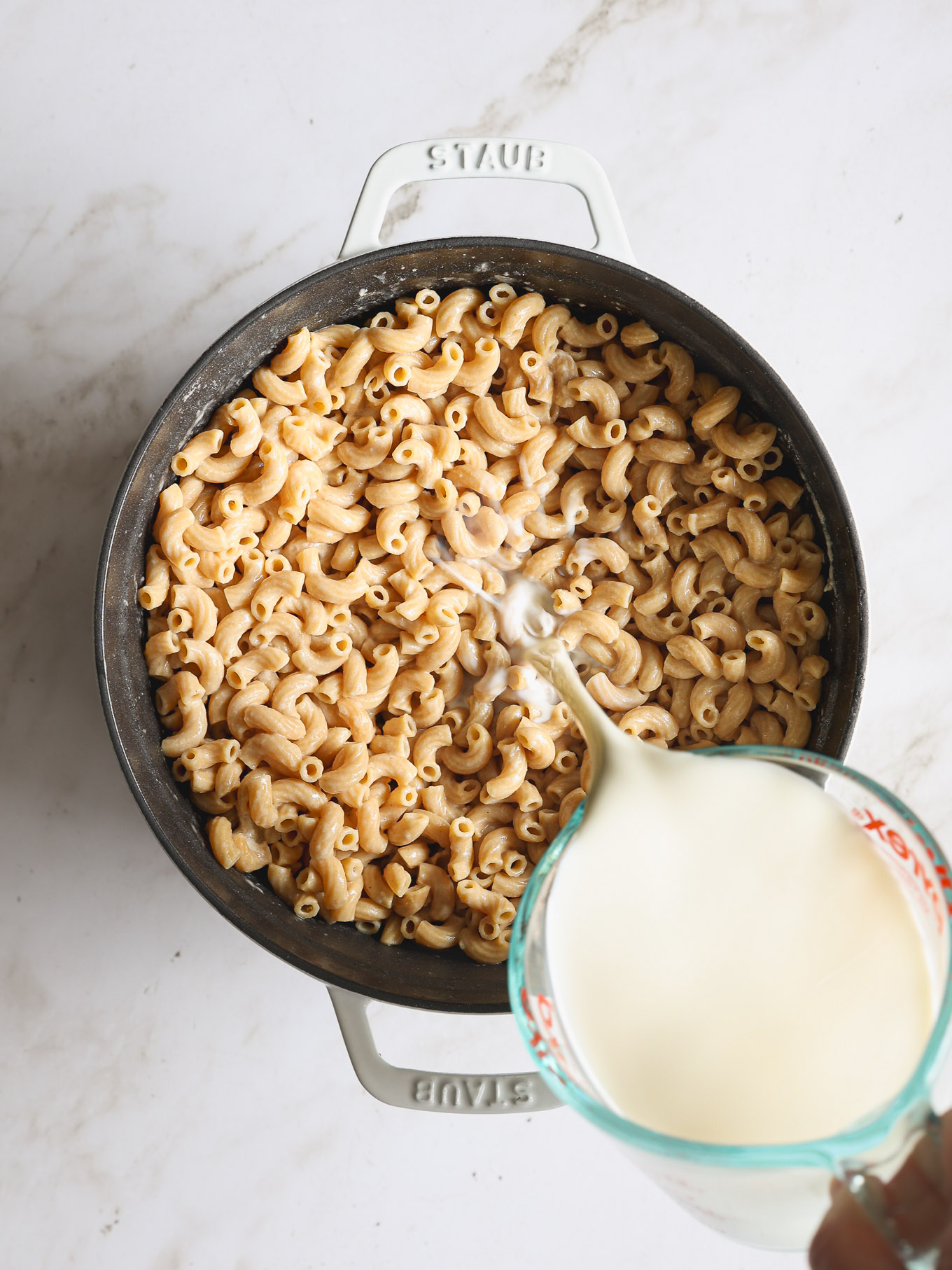 cooked macaroni and cheese with milk in a dutch oven.