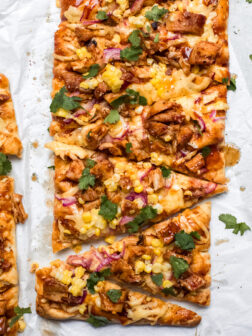 bbq chicken flatbread on white parchment paper.