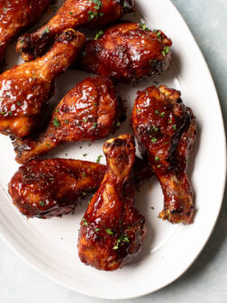 close up roasted bbq chicken legs on a platter.